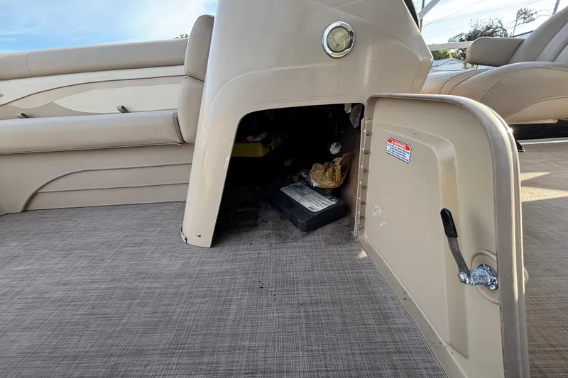 Slide: The Image of 2015 Bennington 20 SSX boat interior with open storage compartment and visible battery. - 29