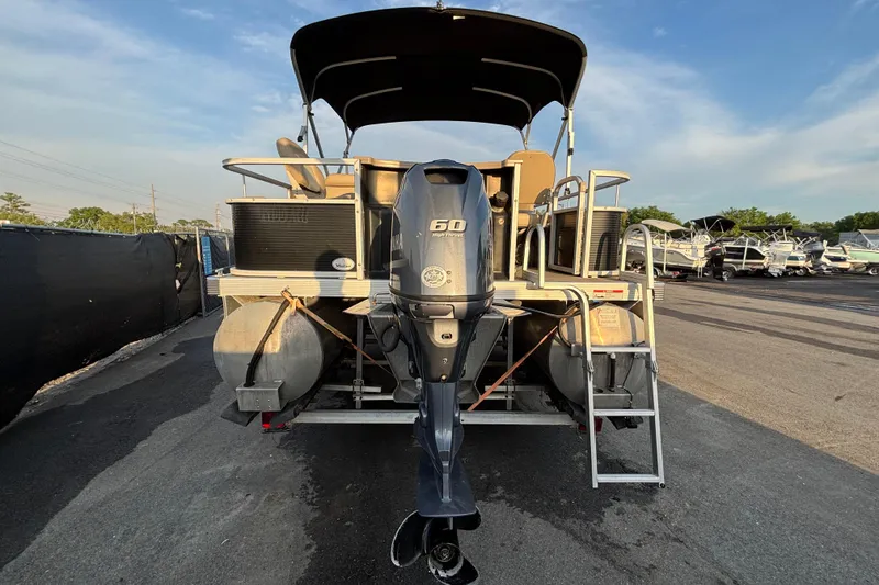 Slide: The Image of 2015 Bennington 20 SSX pontoon boat with Yamaha 60 HP engine, docked outdoors. - 3