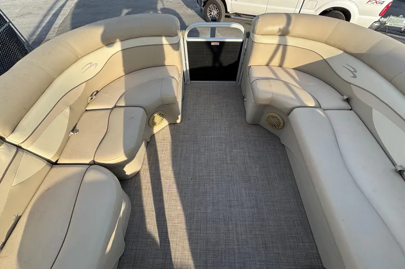 Slide: The Image of 2015 Bennington 20 SSX pontoon boat interior with beige seating and carpeted floor. - 31