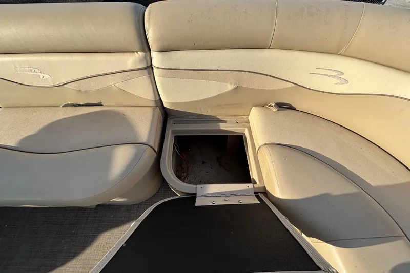 Slide: The Image of 2015 Bennington 20 SSX boat interior with beige seating and open storage compartment. - 42