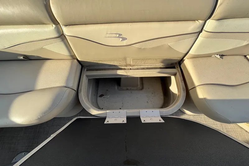 Slide: The Image of 2015 Bennington 20 SSX boat seat storage compartment open, revealing interior space. - 44