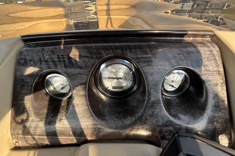 Slide: The Image of Dashboard of a 2015 Bennington 20 SSX boat with gauges for trim, RPM, and fuel. - 54