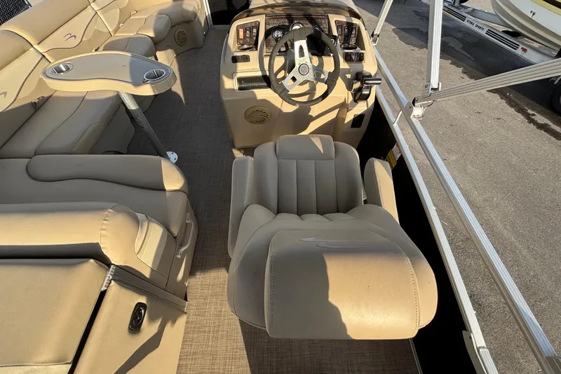 Slide: The Image of Interior of a 2015 Bennington 20 SSX pontoon boat with beige seating and steering console. - 58
