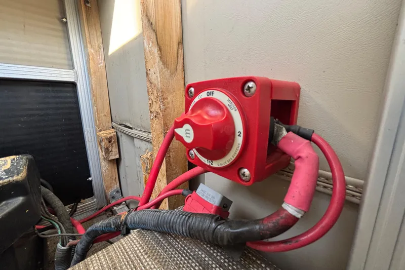 Slide: The Image of Red battery switch in a 2015 Bennington 20 SSX boat, mounted on a wooden panel. - 59