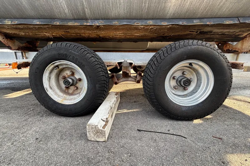 Slide: The Image of Trailer wheels of a 2015 Bennington 20 SSX on pavement with wooden block. - 69