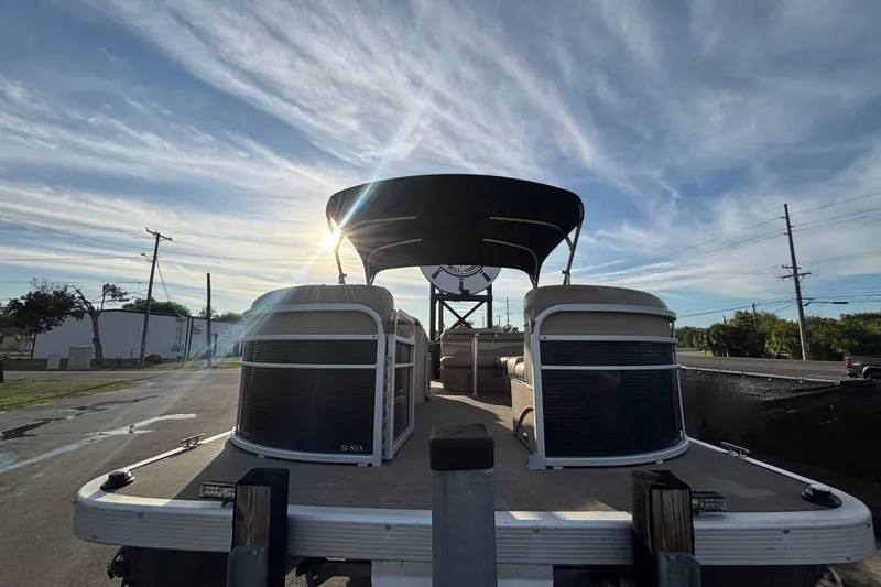 Slide: The Image of 2015 Bennington 20 SSX pontoon boat with canopy under a bright sky. - 7