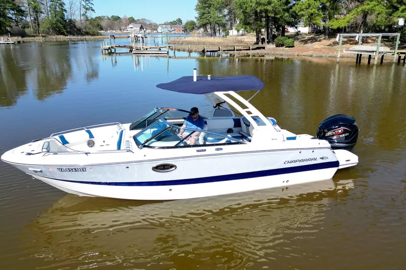 The Image of 2023 Chaparral 250 OSX boat on calm water with trees in the background. - 0
