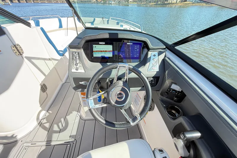 Slide: The Image of 2023 Chaparral 250 OSX boat cockpit with steering wheel and navigation display. - 11