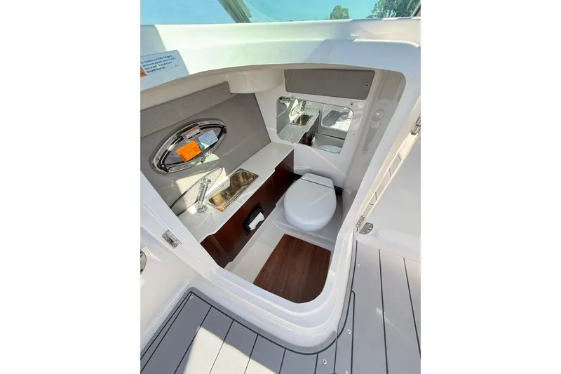 Slide: The Image of 2023 Chaparral 250 OSX boat interior with compact bathroom and sink. - 15