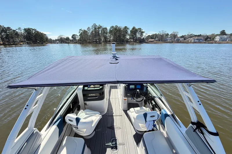 Slide: The Image of 2023 Chaparral 250 OSX boat with canopy on a serene lake. - 21
