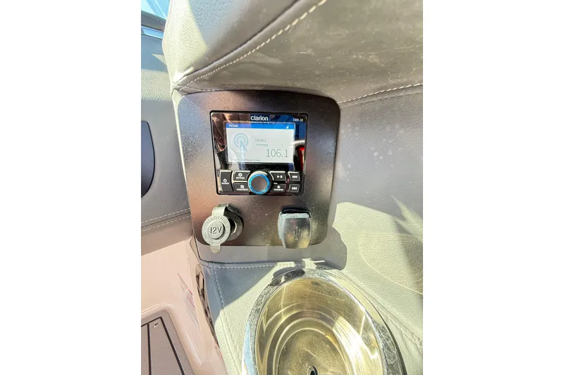 Slide: The Image of 2023 Chaparral 250 OSX boat dashboard with Clarion stereo and 12V outlet. - 23