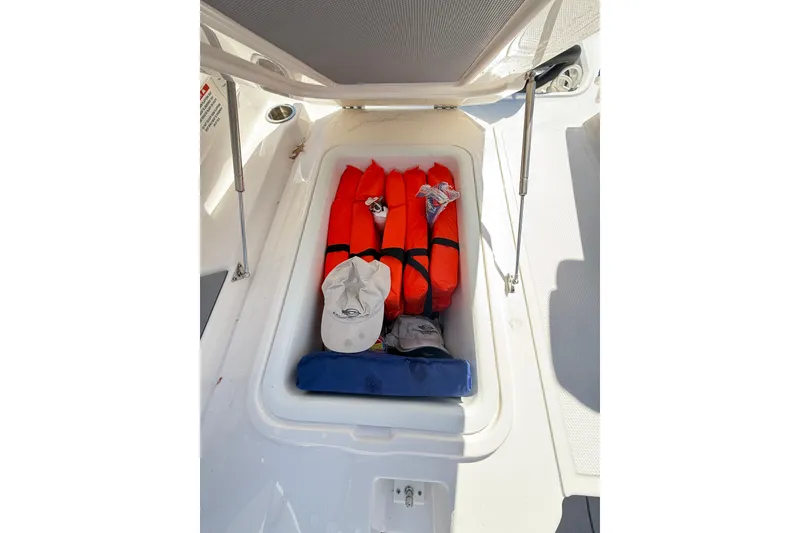 Slide: The Image of Storage compartment in 2023 Chaparral 250 OSX boat with life jackets and accessories. - 35