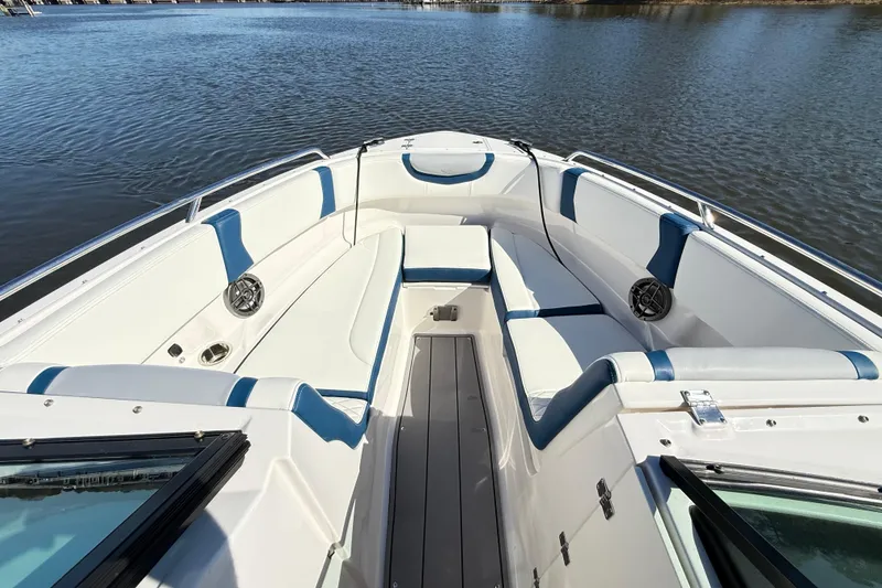 Slide: The Image of 2023 Chaparral 250 OSX boat interior with white and blue seating on calm water. - 9