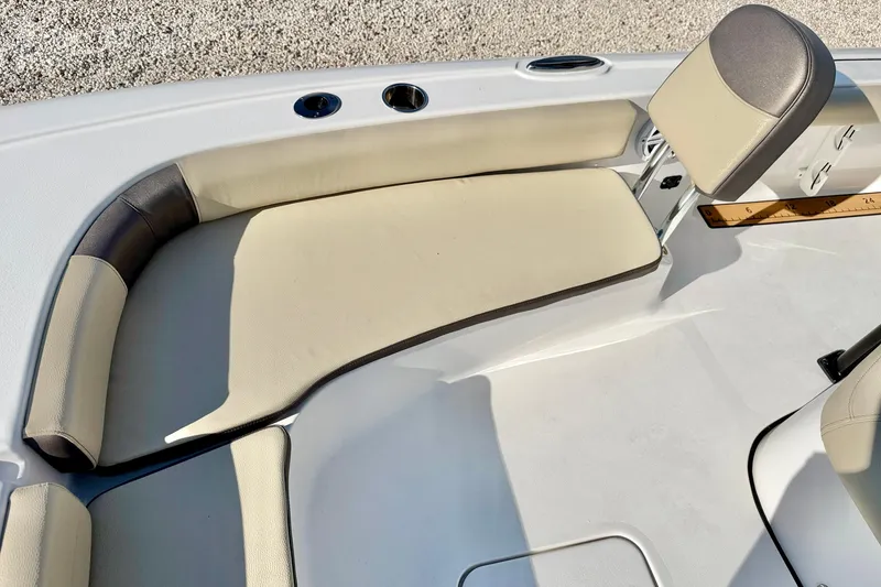 Slide: The Image of 2022 Tidewater 2300 Carolina Bay boat seating area with beige cushions and cup holders. - 11