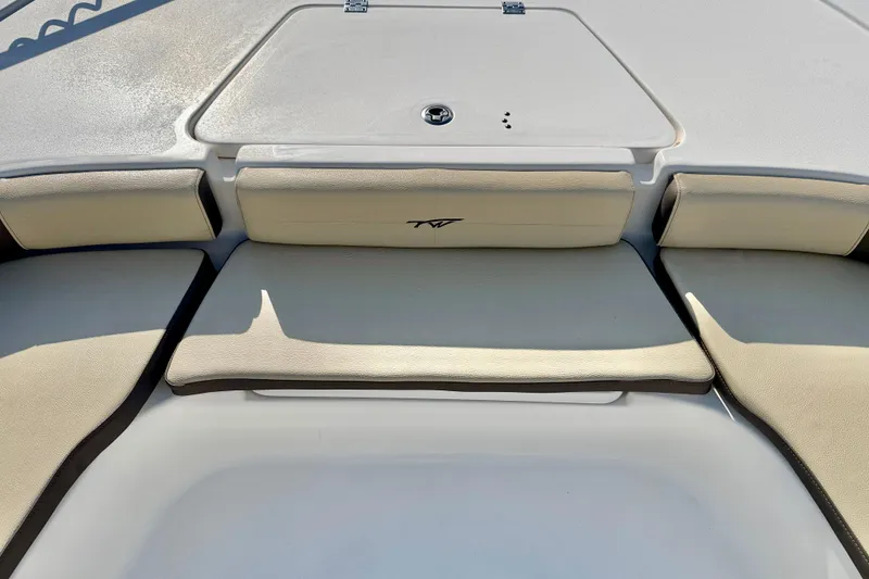 Slide: The Image of 2022 Tidewater 2300 Carolina Bay boat interior with cushioned seating and storage compartment. - 13