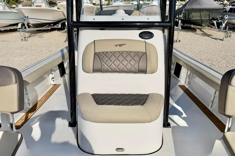 Slide: The Image of 2022 Tidewater 2300 Carolina Bay boat interior with beige seating and diamond stitching. - 15