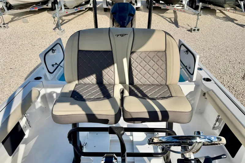 Slide: The Image of 2022 Tidewater 2300 Carolina Bay boat interior with dual cushioned seats and steering wheel. - 18