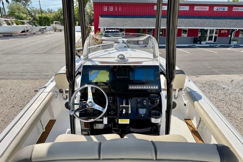 Slide: The Image of 2022 Tidewater 2300 Carolina Bay boat dashboard with navigation screens and steering wheel. - 19