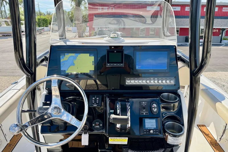 Slide: The Image of 2022 Tidewater 2300 Carolina Bay boat dashboard with navigation screens and steering wheel. - 20