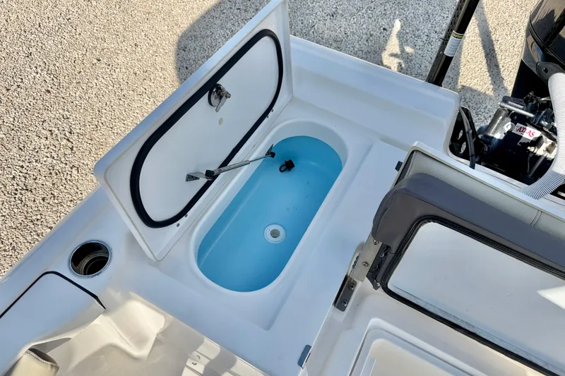 Slide: The Image of 2022 Tidewater 2300 Carolina Bay boat with open storage compartment and visible engine. - 31