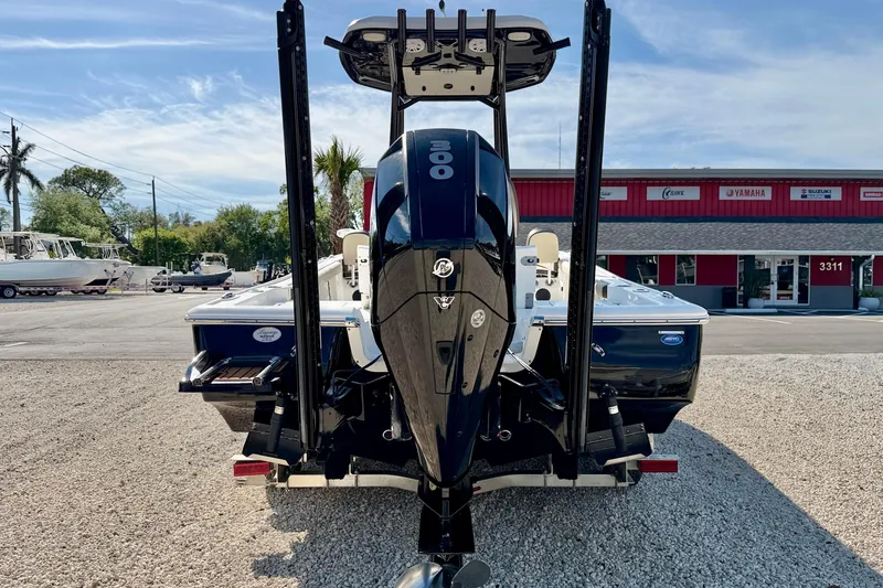 Slide: The Image of 2022 Tidewater 2300 Carolina Bay boat with powerful outboard motor, parked on gravel lot. - 6