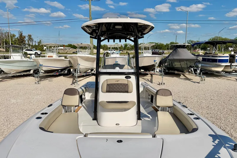 Slide: The Image of 2022 Tidewater 2300 Carolina Bay boat displayed in a dealership lot under a clear sky. - 9