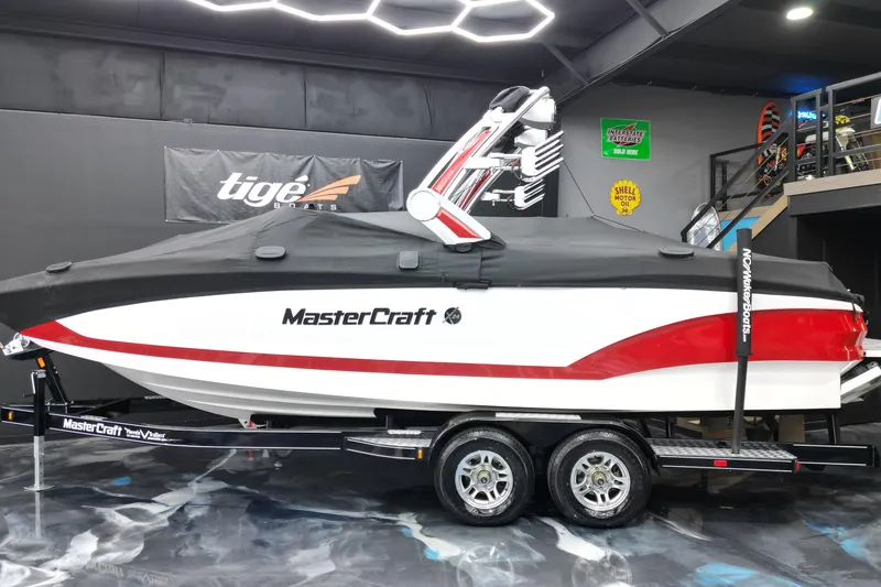Slide: The Image of 2022 MasterCraft X24 boat with cover on trailer in showroom. - 12