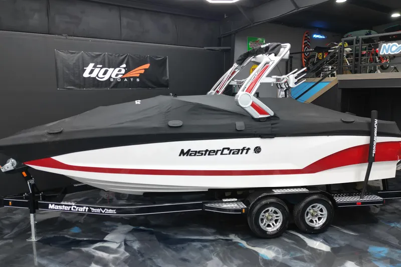 Slide: The Image of 2022 MasterCraft X24 boat with cover on trailer in showroom. - 13