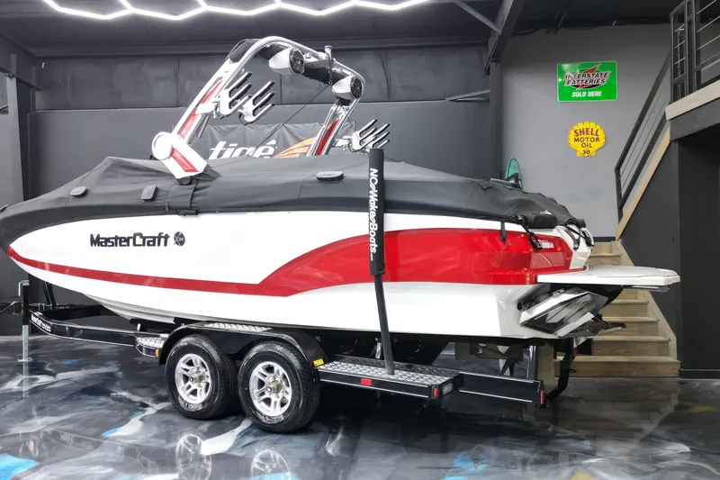 Slide: The Image of 2022 MasterCraft X24 boat on trailer in showroom, covered and ready for transport. - 14