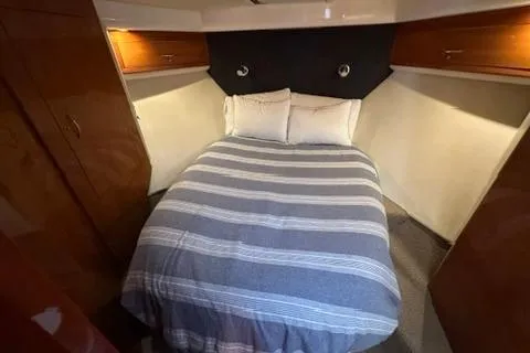 Slide: The Image of Cozy bedroom in 2007 Maritimo 52 yacht with striped bedding and wooden cabinets. - 16
