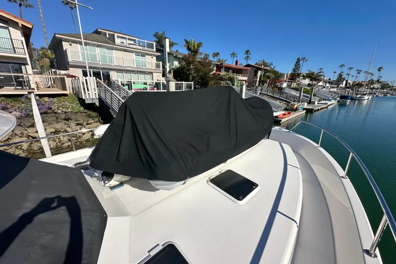 Slide: The Image of 2007 Maritimo 52 yacht docked near waterfront homes under clear blue sky. - 50
