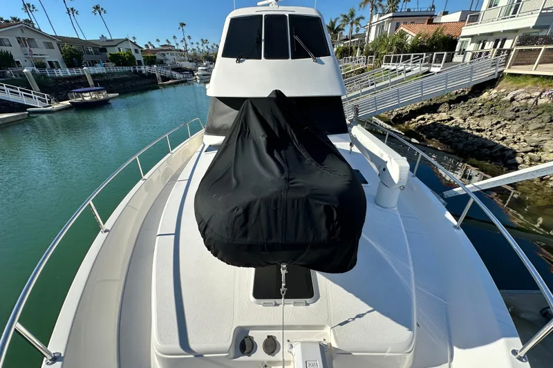 Slide: The Image of 2007 Maritimo 52 yacht docked in a scenic marina with clear blue water. - 52