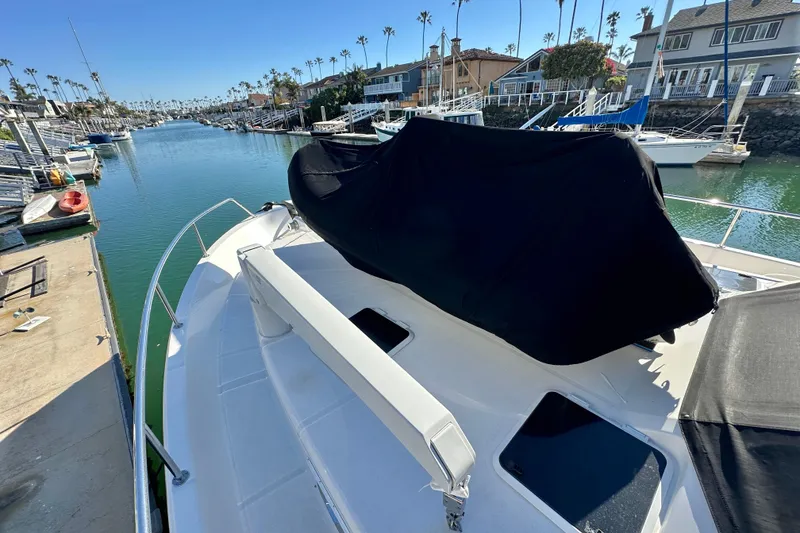 Slide: The Image of 2007 Maritimo 52 yacht docked in a scenic marina with waterfront homes. - 54