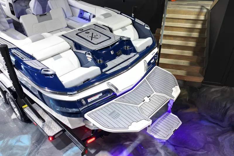 Slide: The Image of 2023 MasterCraft X24 boat with luxurious seating and swim platform, showcased indoors. - 15