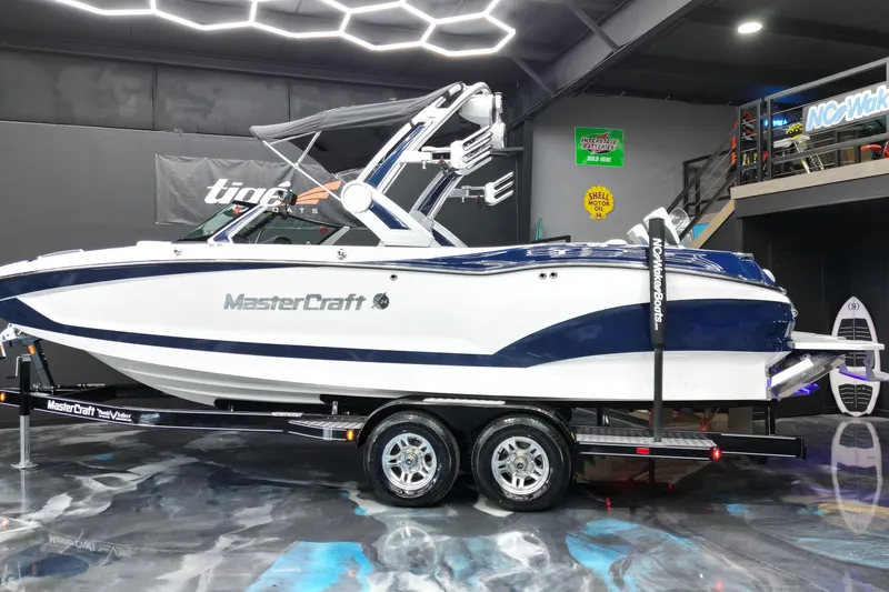 Slide: The Image of 2023 MasterCraft X24 boat displayed indoors on a trailer. - 3