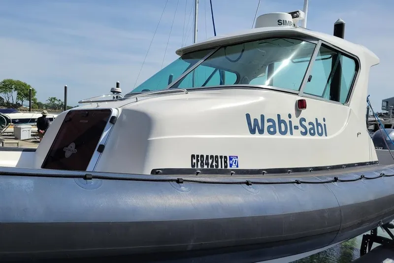 Slide: The Image of 2000 Protector 28 Targa boat named "Wabi-Sabi" docked at a marina. - 1