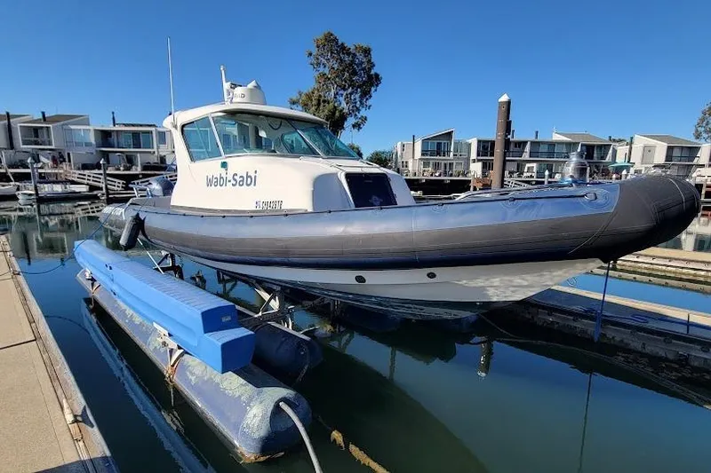 Slide: The Image of 2000 Protector 28 Targa boat named "Wabi-Sabi" docked in a marina. - 10