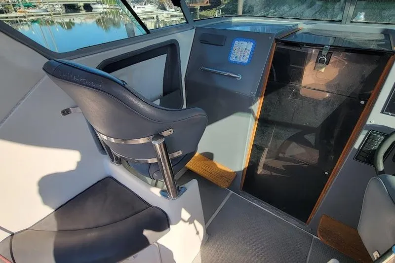 Slide: The Image of Interior of a 2000 Protector 28 Targa boat, featuring a captain's chair and control panel. - 12