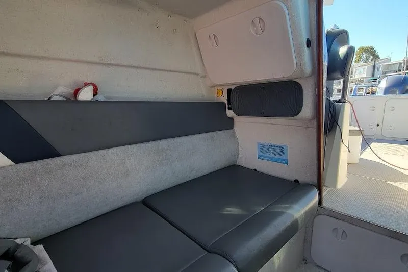 Slide: The Image of Interior of a 2000 Protector 28 Targa boat with cushioned seating. - 15