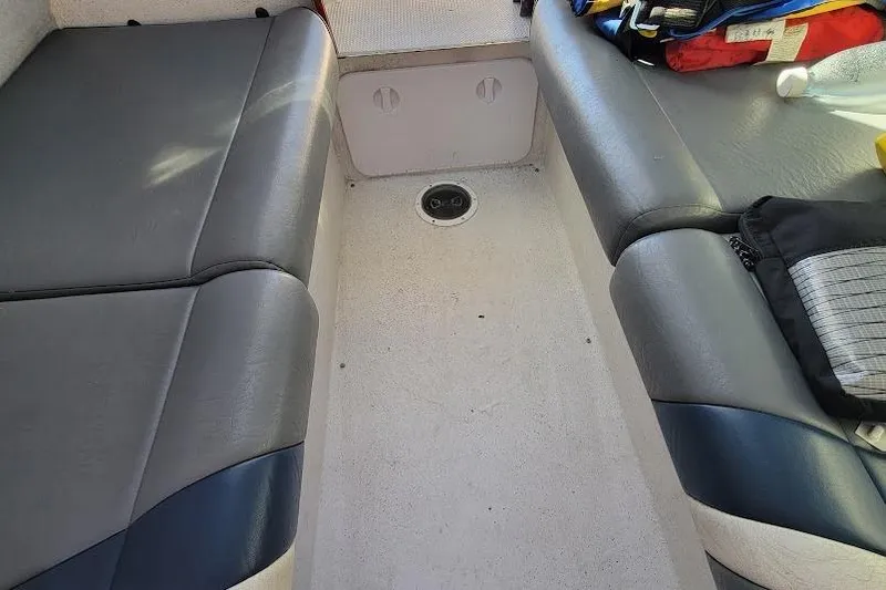Slide: The Image of Interior seating of a 2000 Protector 28 Targa boat, featuring gray upholstery. - 16