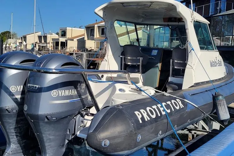 Slide: The Image of 2000 Protector 28 Targa boat with twin Yamaha engines docked at marina. - 2