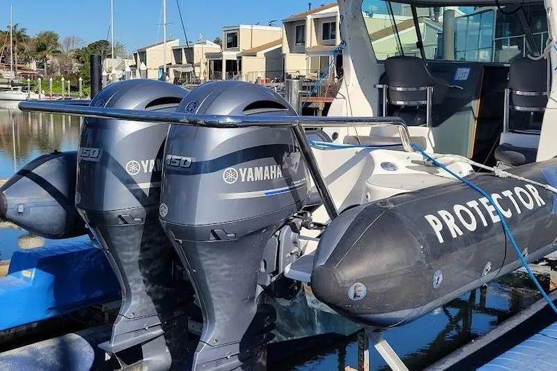 Slide: The Image of 2000 Protector 28 Targa boat with dual Yamaha 150 engines docked in a marina. - 4