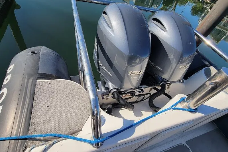 Slide: The Image of Twin outboard motors on a 2000 Protector 28 Targa boat, docked with blue rope. - 5