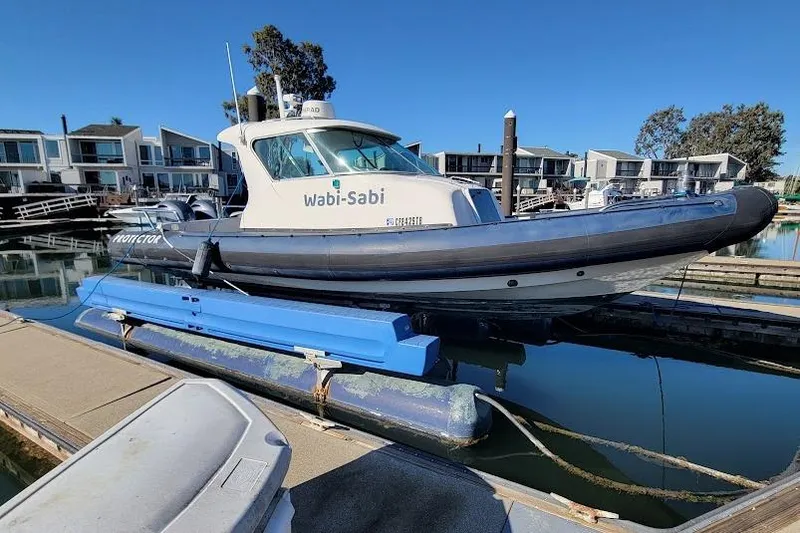 Slide: The Image of 2000 Protector 28 Targa boat docked in marina, labeled "Wabi-Sabi." - 9