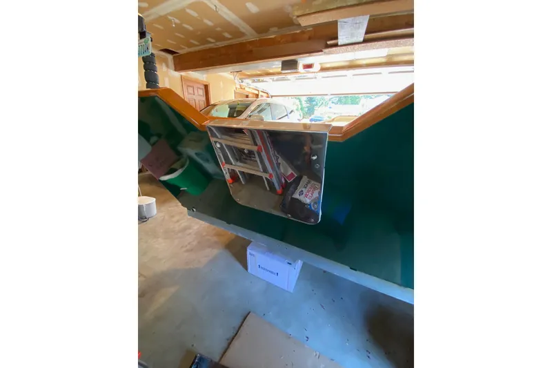 Slide: The Image of Garage interior with a green custom 1996 Don model boat, tools, and storage items. - 13