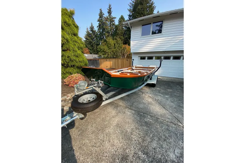 Slide: The Image of Custom 1996 Don boat on trailer in driveway, surrounded by trees and house. - 15