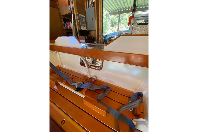 Slide: The Image of Wooden interior of a 1996 Custom Don boat with seat belts and storage. - 18