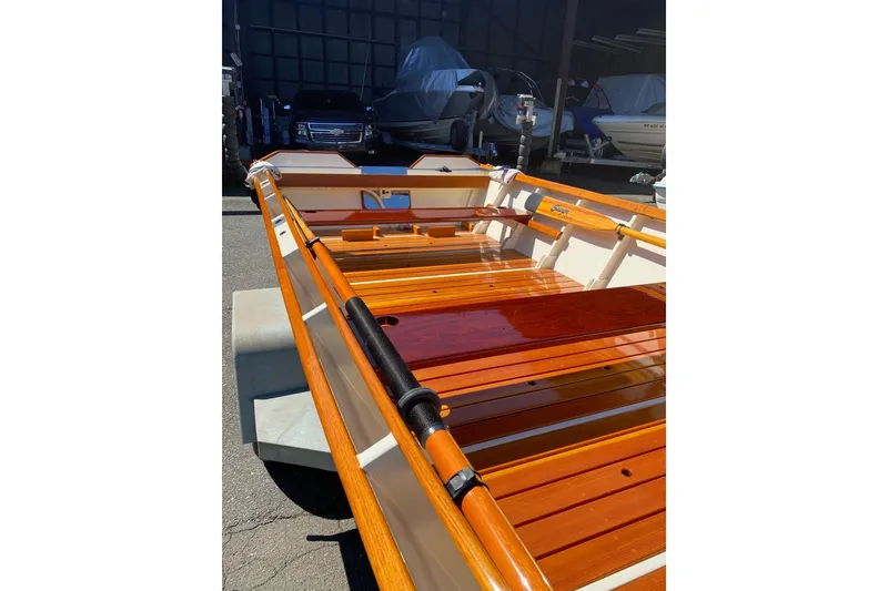 Slide: The Image of Wooden interior of a 1996 Custom Don boat, showcasing polished seats and oars. - 3