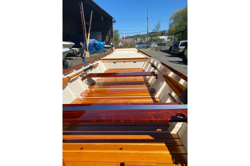 Slide: The Image of Wooden interior of a 1996 Custom Don boat, featuring polished seats and oars. - 5