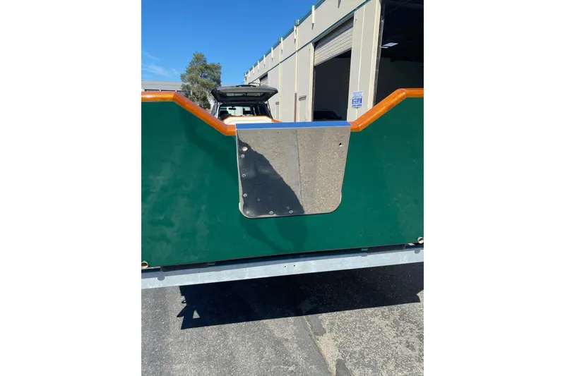 Slide: The Image of Rear view of a 1996 Custom Don boat with green and orange detailing. - 6